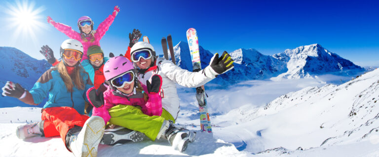 family of smiling skiers with their rental skis