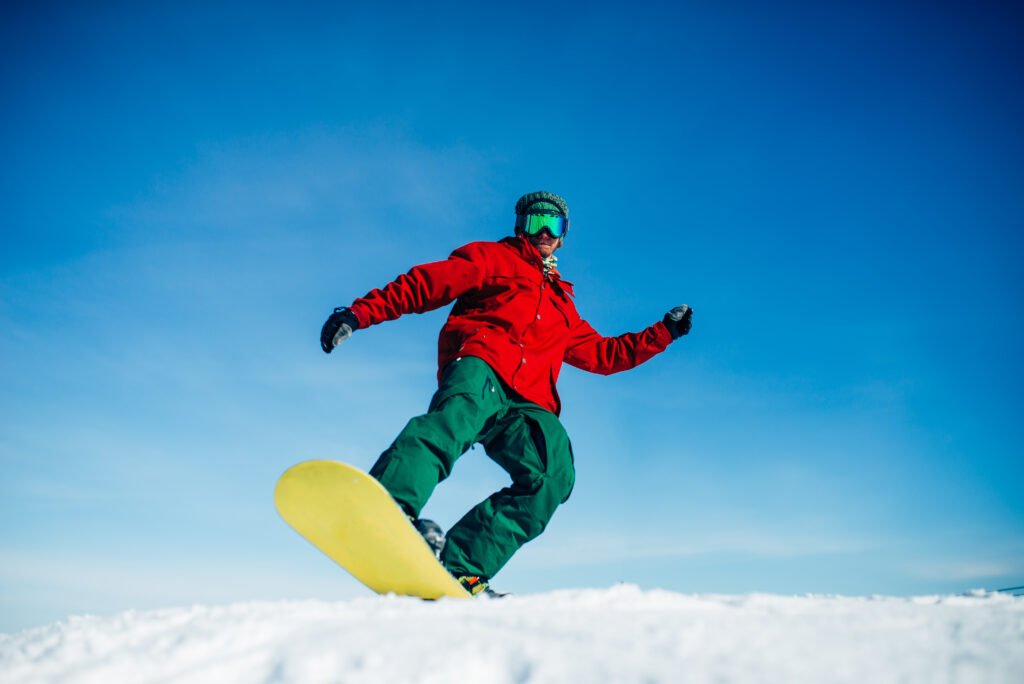 Rental items shown, including jacket, pants, board, boots, and helmet on a man snowboarding