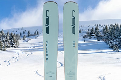 An image of the Park City Sport Demo Package showing the Elan Ripstick on a background of a blue run covered in fresh powder.