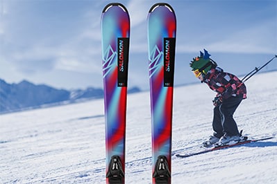 Image of junior package skis on a background that shows a kid skiing down a slope at Park City Mountain Resort