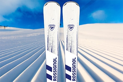 Image of Rossignol Performance Ski Rental package available at Park City Sport on a background of a freshly groomed ski run